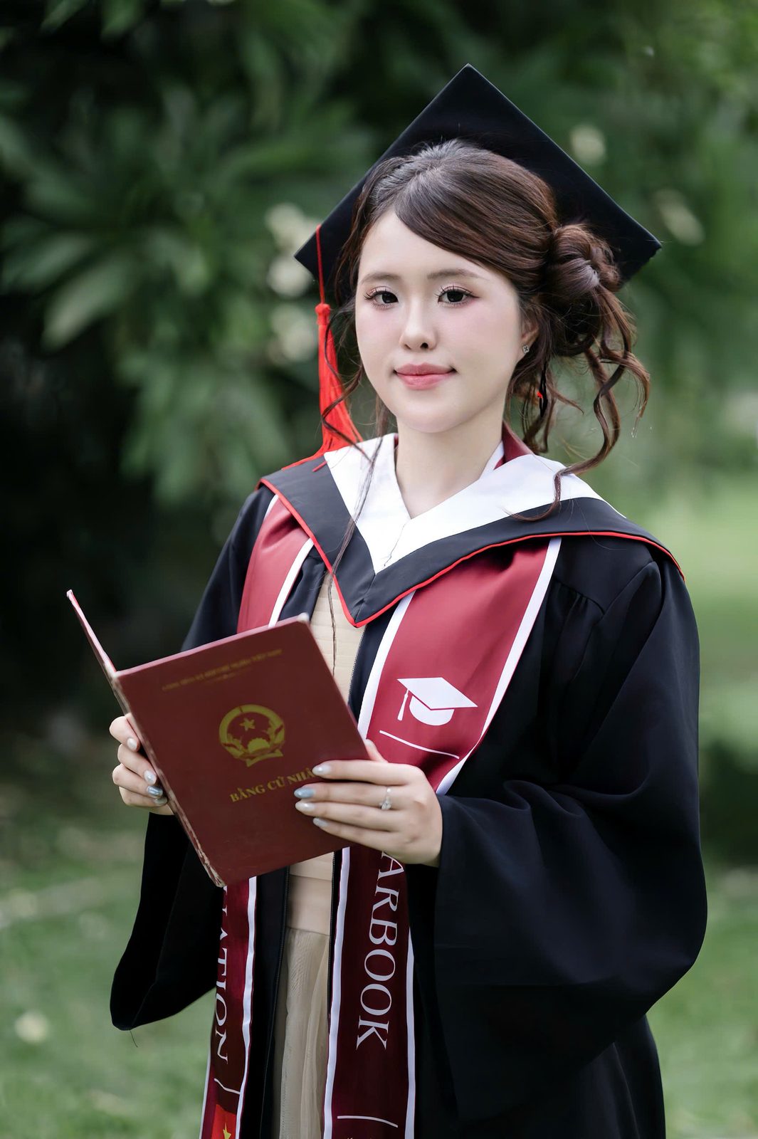 Tân cử nhân trong lễ phục, cầm bằng tốt nghiệp
